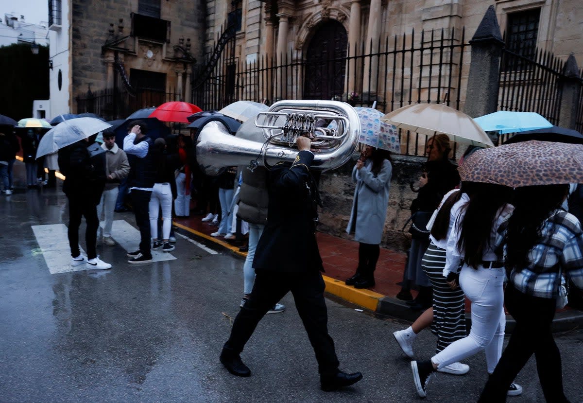 People sheltering from the rain in Spain on Tuesday (REUTERS)