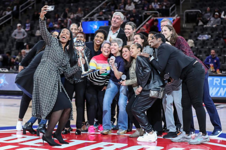 Former Detroit Shock player Swin Cash, center left, takes a selfie at center court during the Pistons' celebration of the 2003 WNBA champion team at halftime on Thursday, March 9, 2023, at Little Caesars Arena.