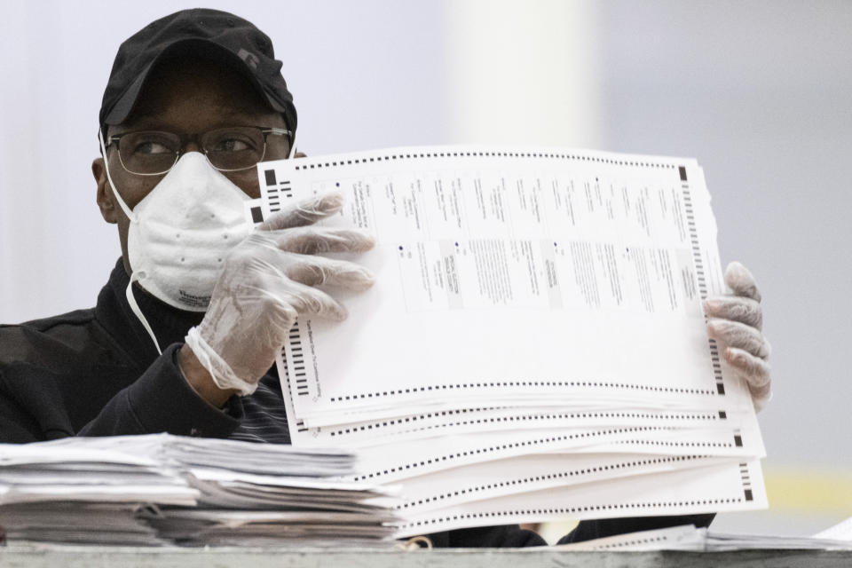 Workers sort and stack ballots in preparation for scanning during a recount, Tuesday, Nov. 24, 2020, in Lithonia, Ga. County election workers across Georgia have begun an official machine recount of the roughly 5 million votes cast in the presidential race in the state. The recount was requested by President Donald Trump after certified results showed him losing the state to Democrat Joe Biden by 12,670 votes, or 0.25% (AP Photo/Ben Gray)