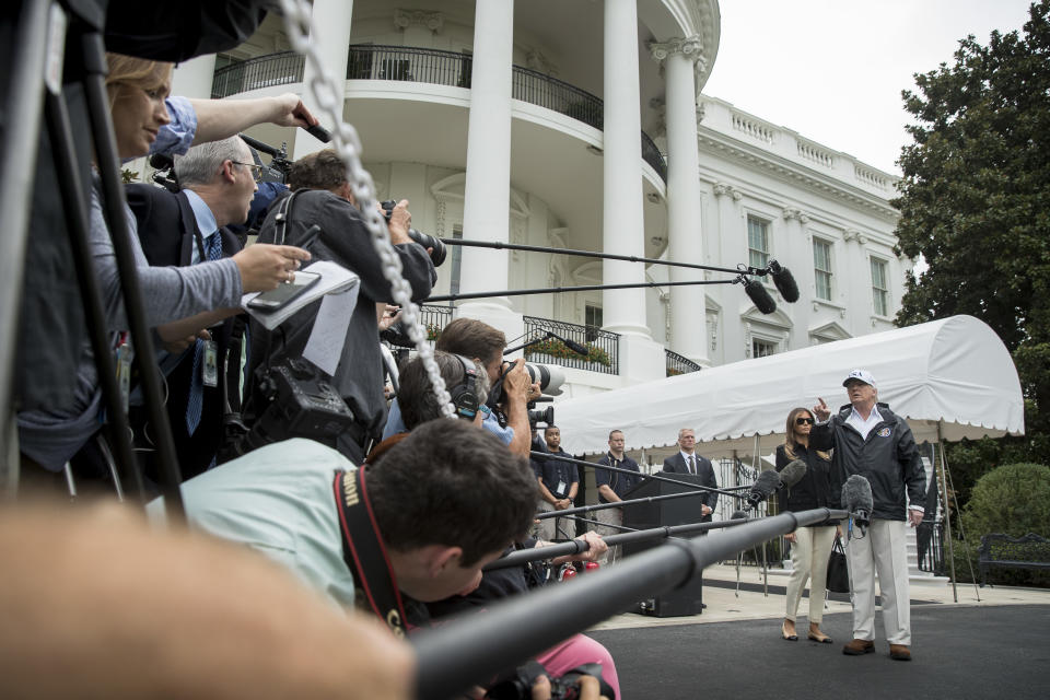 <p>President Donald Trump accompanied by first lady Melania Trump, second from right, takes a question from a member of the media before boarding Marine One on the South Lawn of the White House in Washington, Thursday, Sept. 14, 2017, for a short trip to Andrews Air Force Base and then on to Fort Myers, Fla. to meet with citizens impacted by Hurricane Irma. (Photo: Andrew Harnik/AP) </p>