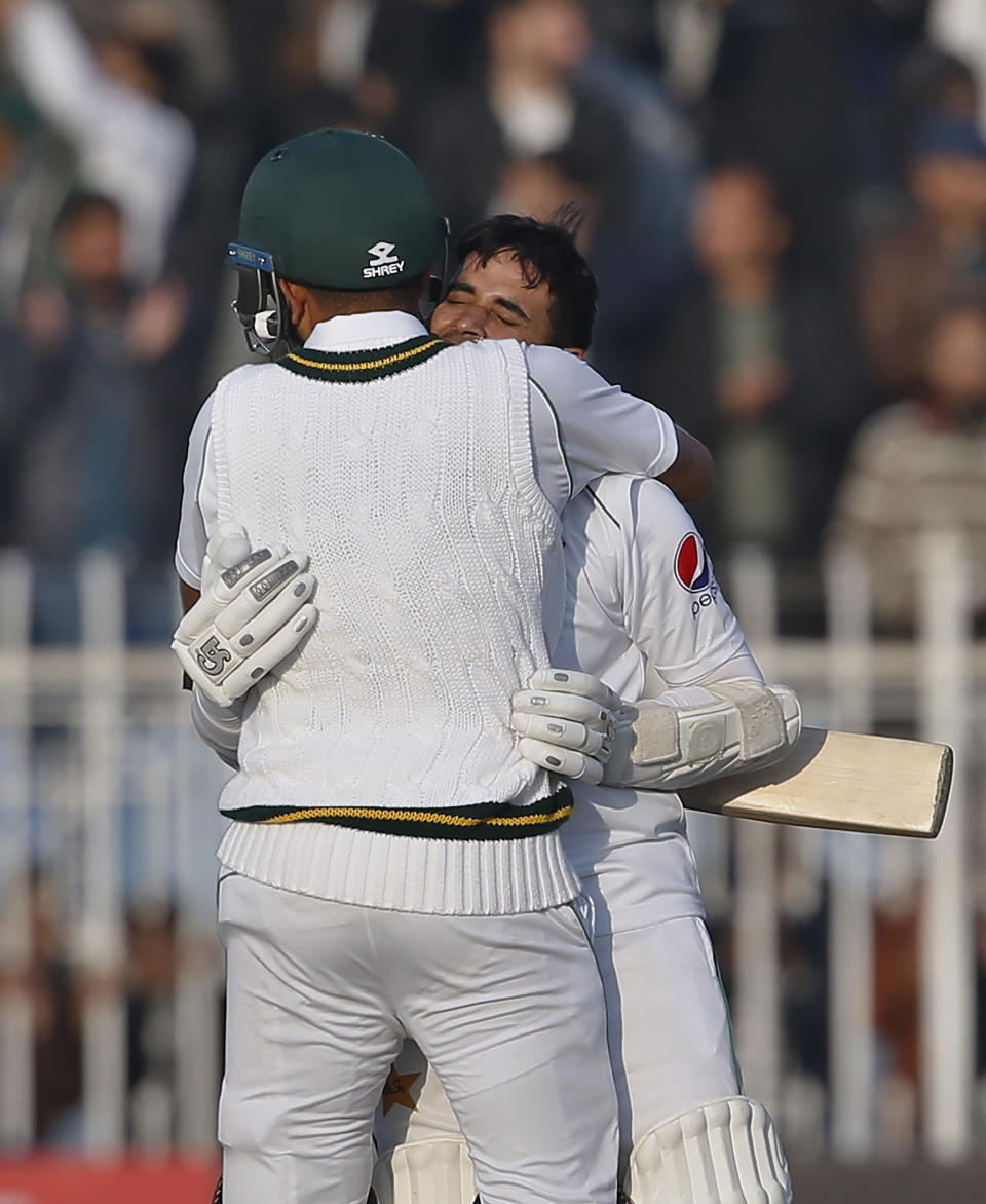 Pakistani batman Abid Ali is congratulated by teammate Babar Azam after completing his century during the fifth-day of the 1st cricket test match between Pakistan and Sri Lanka, in Rawalpindi, Pakistan, Sunday, Dec. 15, 2019. (AP Photo/Anjum Naveed)