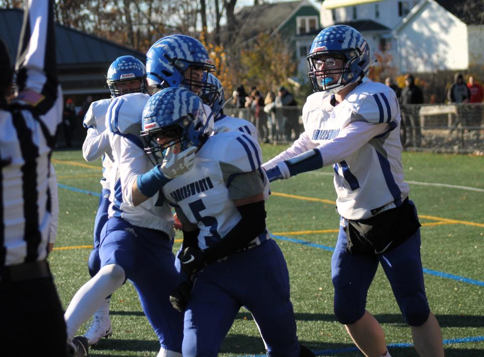 Somersworth's Tayshawn Sheppard is congratulated by teammates following his go-ahead touchdown during Saturday's Division IV championship game against Newport at Bank of America Stadium in Laconia.