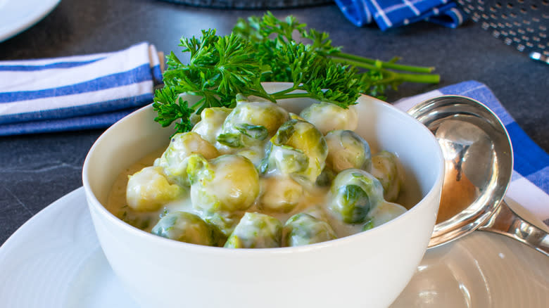 Boiled Brussels sprouts in cream sauce in serving bowl