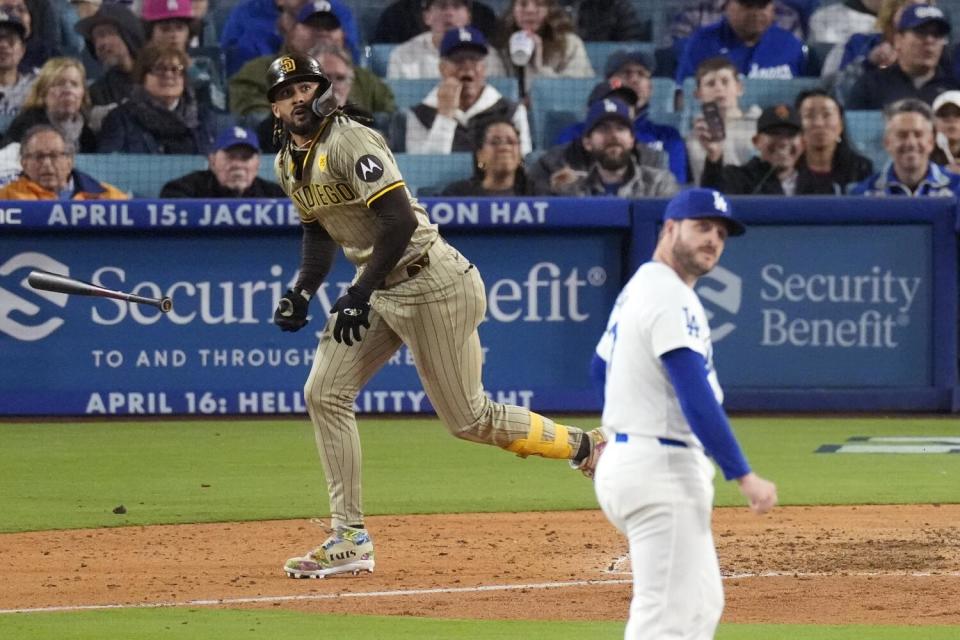 San Diego's Fernando Tatis Jr. runs toward first base while Dodgers reliever Ryan Brasier looks back to the outfield.