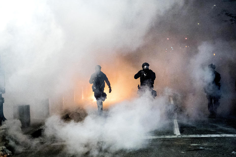 Federal officers use crowd control munitions to disperse Black Lives Matter protesters outside the Mark O. Hatfield United States Courthouse on Tuesday, July 21, 2020, in Portland, Ore. (AP Photo/Noah Berger)