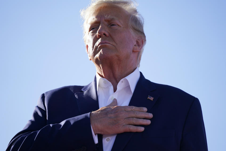 Former President Donald Trump stands for the national anthem during a campaign rally at Waco Regional Airport, Saturday, March 25, 2023, in Waco, Texas. (AP Photo/Evan Vucci)