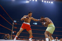 <p>Muhammad Ali, red trunks, and Joe Frazier, green trunks, are shown during round 5 or 6 of their bout in New York’s Madison Square Garden, March 8, 1971. (John Lindsay/AP Photo)</p> 