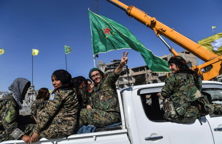 Female members of the Syrian Democratic Forces celebrate on the iconic Al-Naim square in Raqa on October 18, 2017, after retaking the city from the Islamic State group