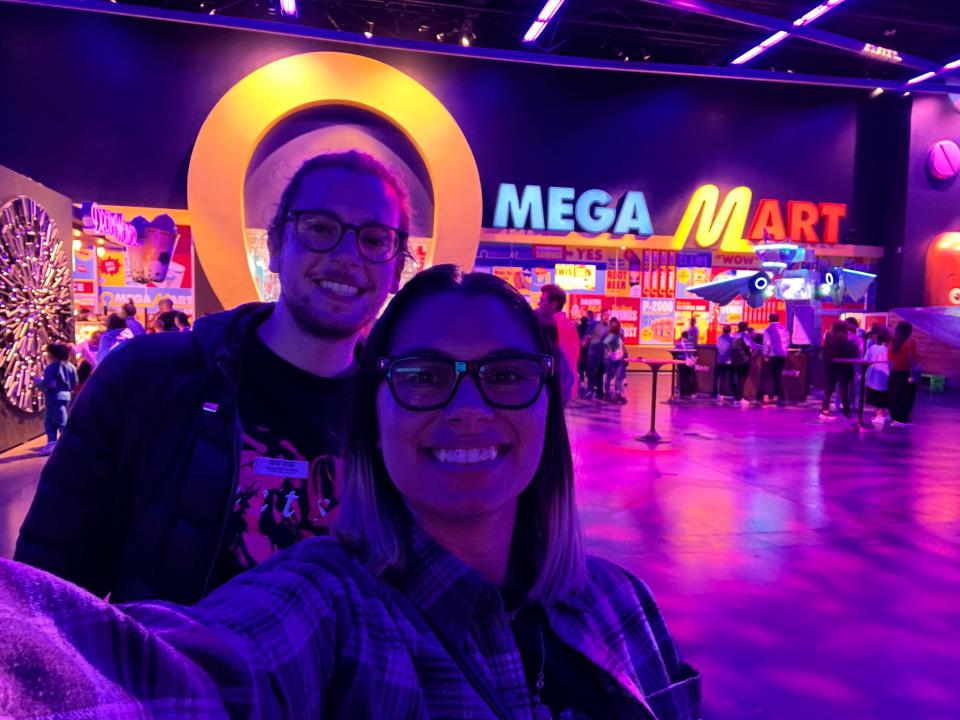 chris and rebecca posing in front of the entrance to omega mart in area 15 in las vegas