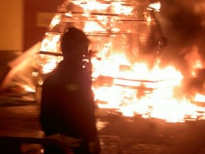 Fireman in front of burning house