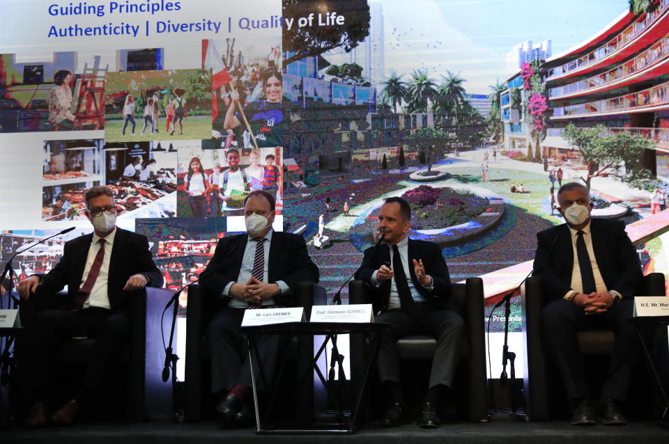 Governor of Beirut Marwan Abboud, right, listens to Hermann Schnell, Managing Director at Colliers Germany and Head of Architecture and Workplace Consulting, second right, who is speaking during a press conference as he sits next of Lars Greiner, Associate Partner responsible for Middle East and Africa HPC, Hamburg Port consulting, center, and Suheil Mahayni, managing Director of Hamburg Port Consulting, left, in Beirut, Lebanon, Friday, April 9, 2021. Representatives of several private German companies on a visit Friday to Lebanon outlined an elaborate, multi-billion dollar study to rebuild the port of Beirut and surrounding neighborhoods destroyed by a massive explosion last year and nearby city neighborhoods. (AP Photo/Hussein Malla)