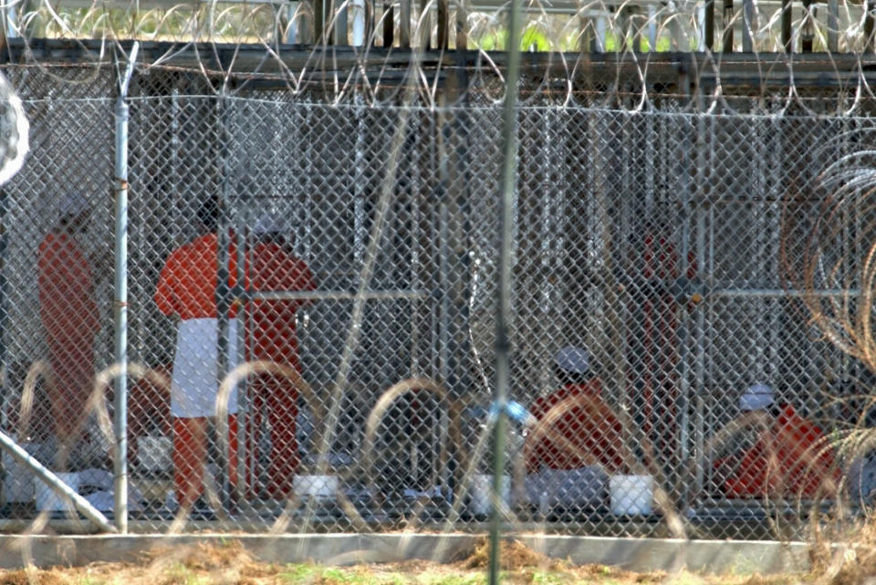 FILE - In this Feb. 2, 2002, file photo detainees from Afghanistan sit in their cells at Camp X-Ray at the U.S. Naval Base in Guantanamo Bay, Cuba. At the time the image was taken there were 158 al-Qaida and Taliban prisoners being held at the camp. The White House says it intends to shutter the prison on the U.S. base in Cuba, which opened in January 2002 and where most of the 39 men still held have never been charged with a crime. (AP Photo/Lynne Sladky, File)