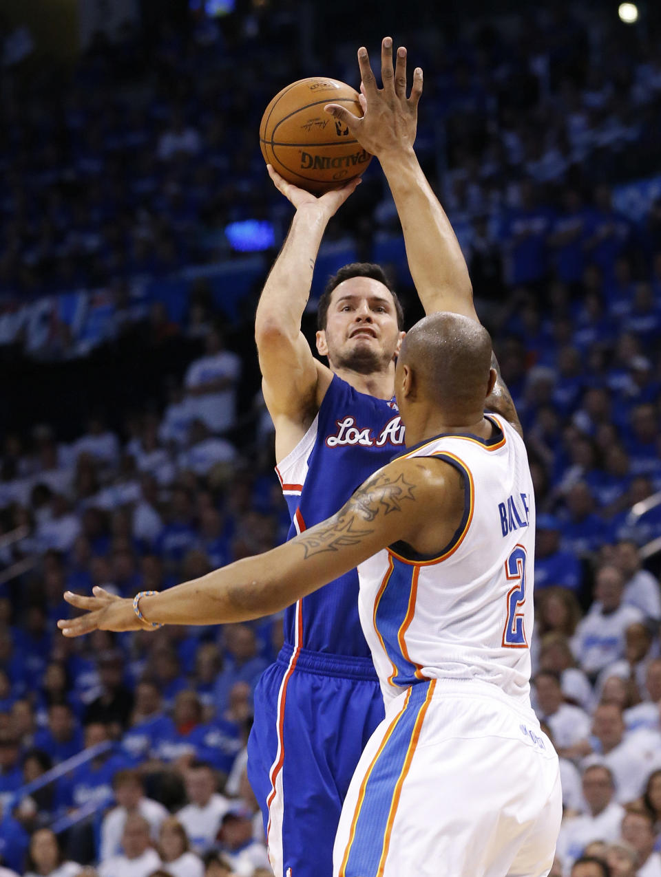 Los Angeles Clippers guard J.J. Redick shoots as Oklahoma City Thunder forward Caron Butler (2) defends in the second quarter of Game 2 of the Western Conference semifinal NBA basketball playoff series in Oklahoma City, Wednesday, May 7, 2014. (AP Photo/Sue Ogrocki)