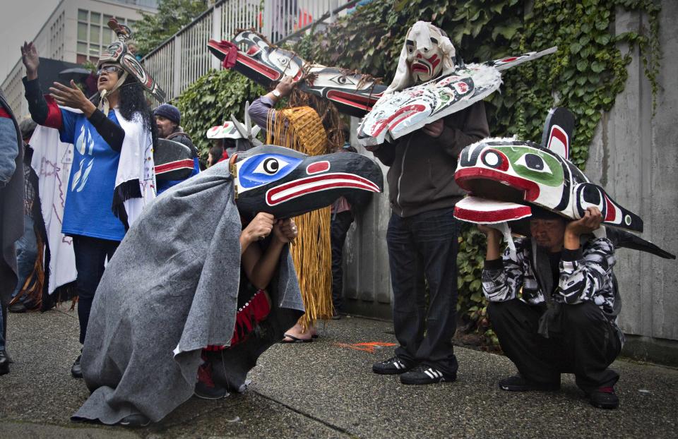 First Nations' participants whear traditional masks while waiting to take part in a Truth and Reconciliation march in Vancouver