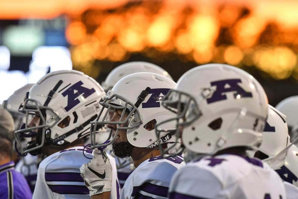 Albany players watch as the sun sets during the game Friday, Sept. 24, 2021, at Little Falls High School.