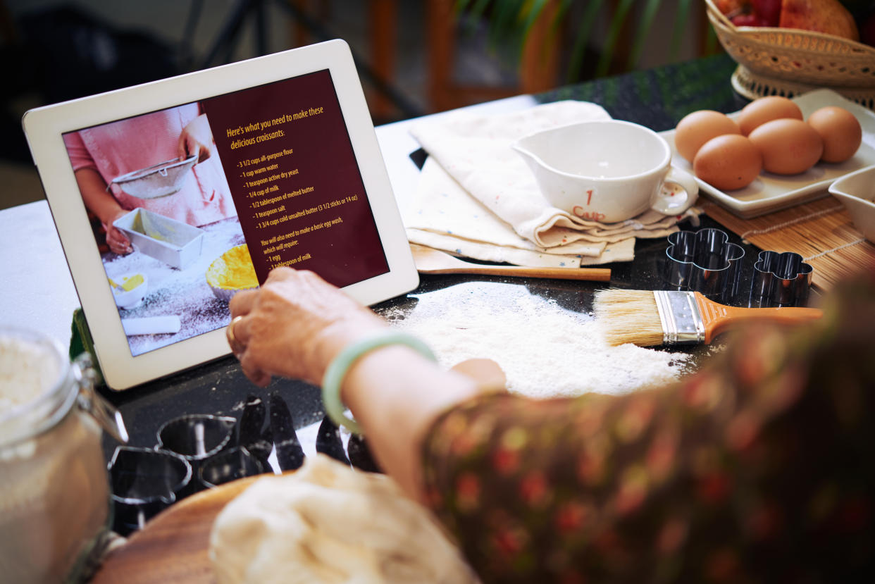 Woman following recipe on tablet when cooking cake