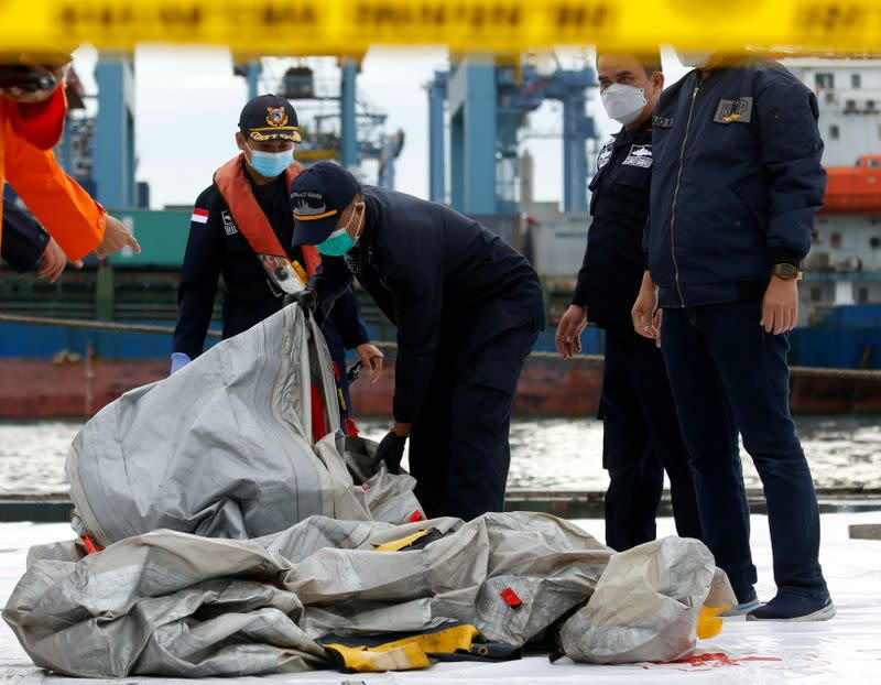 Los miembros del equipo de rescate de Indonesia transportan lo que se cree que son los restos del vuelo del avión de Sriwijaya Air SJ182 que se estrelló en el mar, en el puerto de la Terminal Internacional de Contenedores de Yakarta, en Yakarta (Indonesia), el 10 de enero de 2021