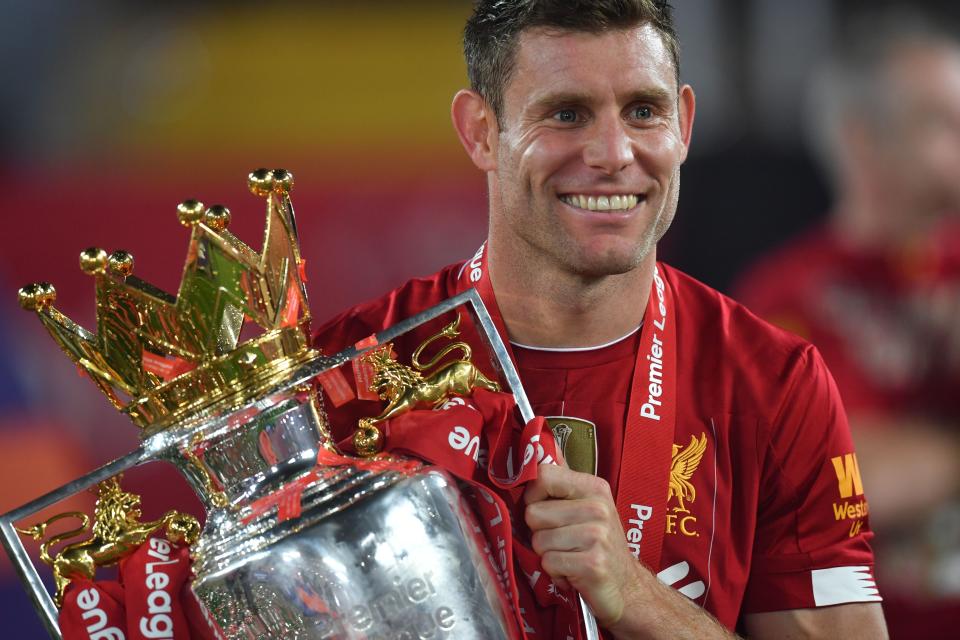 Liverpool's English midfielder James Milner poses with the Premier League trophy during the presentation following the English Premier League football match between Liverpool and Chelsea at Anfield in Liverpool, north west England on July 22, 2020. - Liverpool on Wednesday lifted the Premier League trophy at the famous Kop stand at Anfield after their final home game of the season. With no fans able to attend due to the COVID-19 coronavirus pandemic, Liverpool said the idea for the trophy lift was to honour the club's fans, but Liverpool manager Jurgen Klopp urged fans to respect social distancing measures, after thousands gathered around the club's stadium and in the city centre following their coronation as champions last month. (Photo by Paul ELLIS / POOL / AFP) / RESTRICTED TO EDITORIAL USE. No use with unauthorized audio, video, data, fixture lists, club/league logos or 'live' services. Online in-match use limited to 120 images. An additional 40 images may be used in extra time. No video emulation. Social media in-match use limited to 120 images. An additional 40 images may be used in extra time. No use in betting publications, games or single club/league/player publications. /  (Photo by PAUL ELLIS/POOL/AFP via Getty Images)