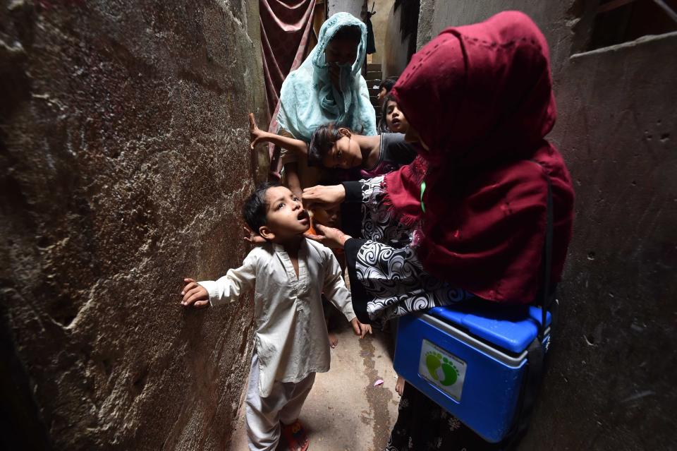 A health worker administers polio vaccine drops to a child 