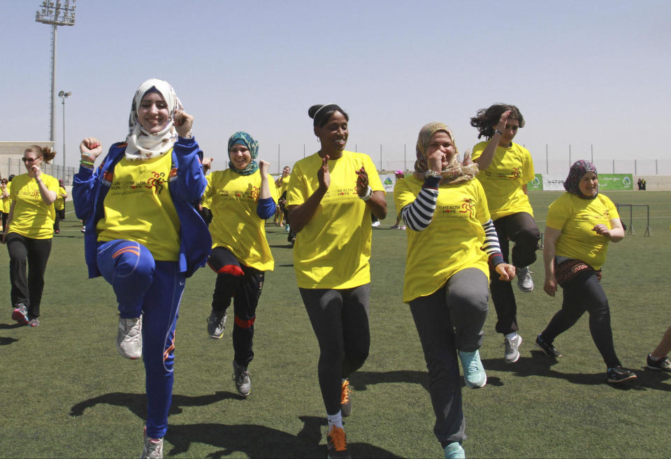 American track and field great Jackie Joyner-Kersee, center, jogs with Palestinian women in the West Bank city of Ramallah, Thursday, April 17, 2014. The three-time Olympic gold medalist visited the West Bank to encourage Palestinian women to be physically active. (AP Photo/Nasser Shiyoukhi)