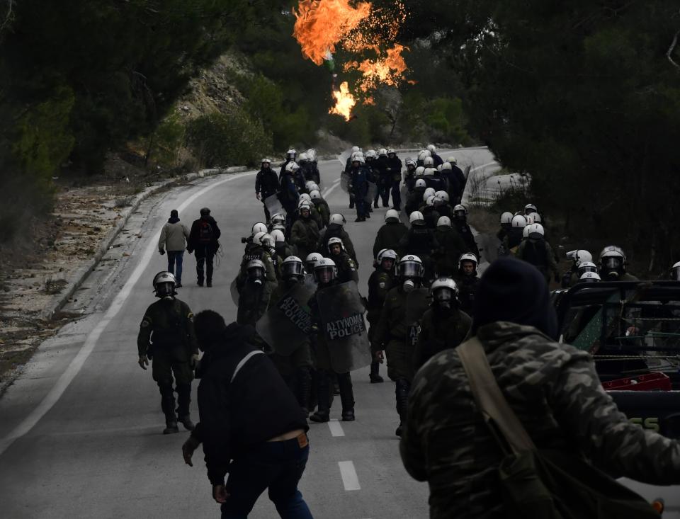 A protester throws a petrol bomb against riot police during clashes in Diavolorema near the area where the government plans to build a new migrant detention center, on the northeastern Aegean island of Lesbos, Greece, Wednesday, Feb. 26, 2020. Local authorities declared a 24-hour strike on two eastern Greek islands Wednesday to protest government plans to build new migrant detention camps there. (AP Photo/Michael Varaklas)