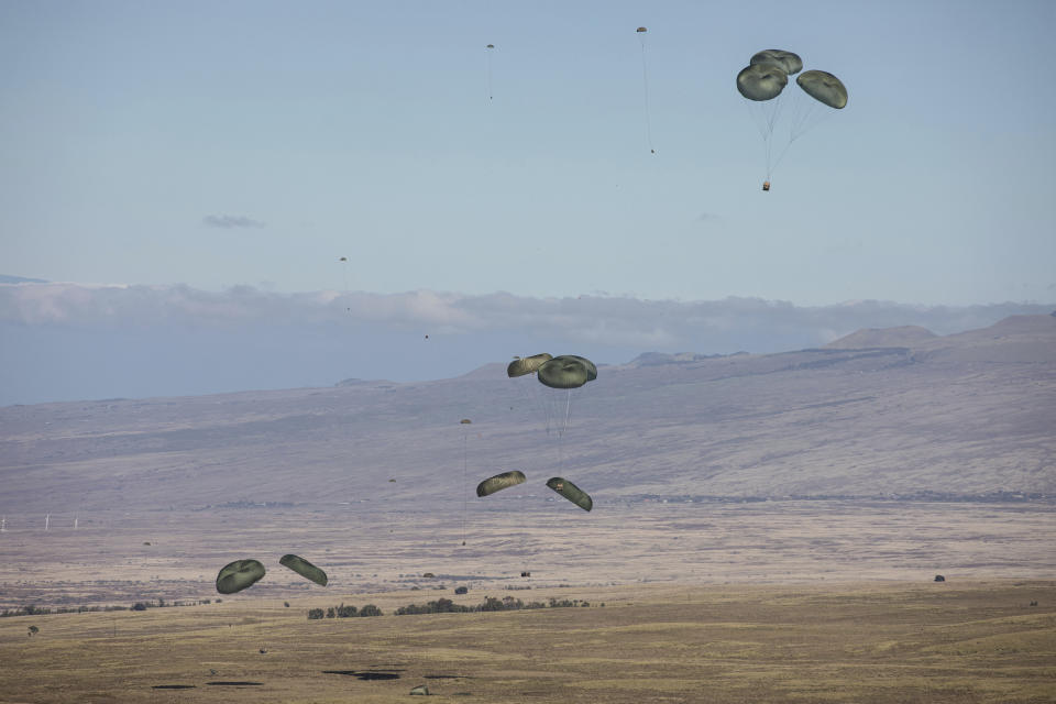In this photo released by the U.S. Army, U.S. Air Force conducts an airdrop during Joint Pacific Multinational Readiness Center (JPMRC), at Pohakuloa Training Area, Hawaii, Nov. 4, 2023. In the largest-scale training held in Hawaii so far, more than 5,000 troops from the 25th Infantry Division, along with units from New Zealand, Indonesia, Thailand and Britain and supported by the U.S. Air Force, have been practicing fighting in an island jungle environment against an advanced enemy force, with exercises including paratrooper drops, a long range air assault, and re-supply by air and sea. (Spc. Abreanna Goodrich/U.S. Army via AP)
