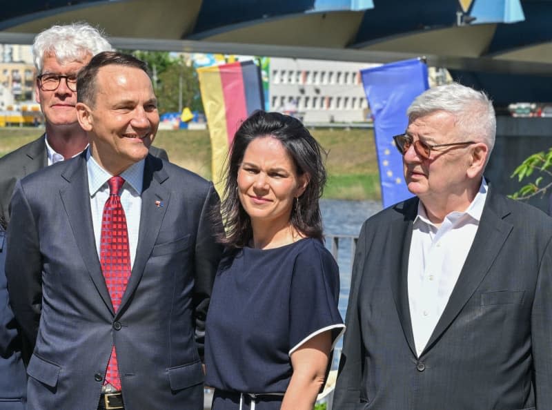 (LR) Radoslaw Sikorski, Minister for Foreign Affairs of Poland, Annalena Baerbock, Minister for Foreign Affairs of Germany, and Joschka Fischer, former Minister for Foreign Affairs of Germany, in front of the bridge between the twin city of Frankfurt (Oder) and Polish city of Slubice on the 20th anniversary of Poland's accession to the EU.  Patrick Pleul/dpa