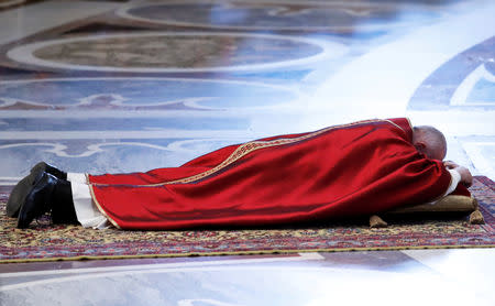Pope Francis lies on the floor during the Good Friday Passion of the Lord service in Saint Peter's Basilica at the Vatican, April 19, 2019. REUTERS/Remo Casilli