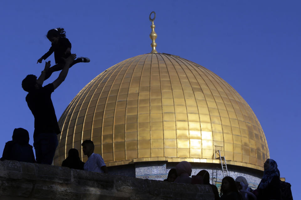 A girl is tossed into the air as people gather for Eid al-Fitr prayers at the Dome of the Rock Mosque in the Al-Aqsa Mosque compound in the Old City of Jerusalem, Thursday, May 13, 2021. Eid al-Fitr, festival of breaking of the fast, marks the end of the holy month of Ramadan. (AP Photo/Mahmoud Illean)