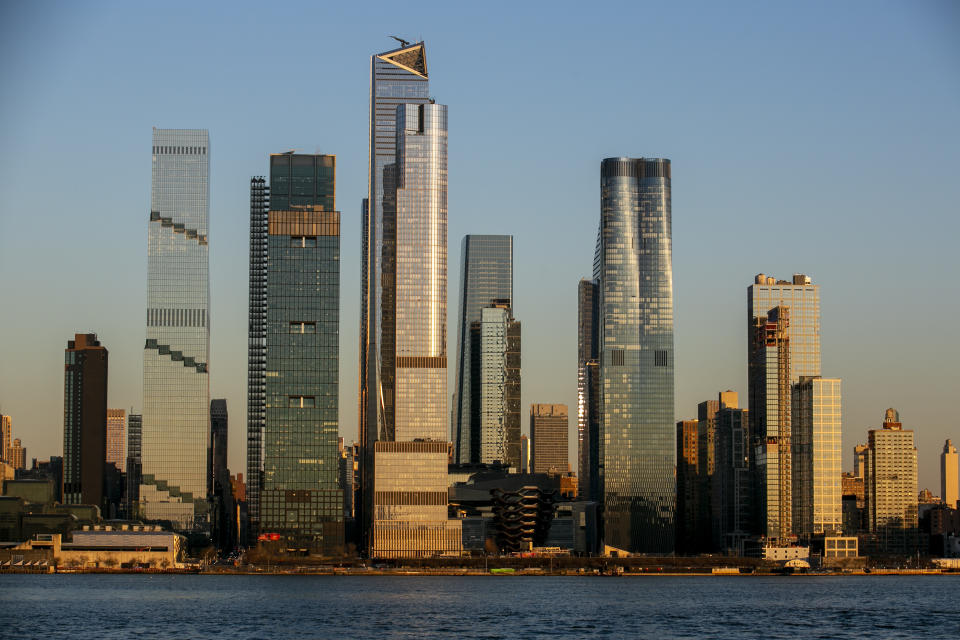 FILE - Light from the setting sun falls on the Hudson Yards neighborhood in the borough of Manhattan in New York City, as seen from the Weehawken Pier in Weehawken, New Jersey, on Wednesday, March 22, 2023. New Jersey is incentivizing taxpayers who work from home for New York based employers to sue New York in court for taxing their wages. (AP Photo/Ted Shaffrey, File)