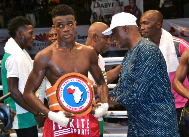 Nigeria's Rilwan Babatunde (L), popularly called 'Babyface', is decorated with a belt after beating Benin's Djossou Agoy Basile during a West African Welterweight GOtv title fight at the National Stadium in Lagos, on April 15, 2018