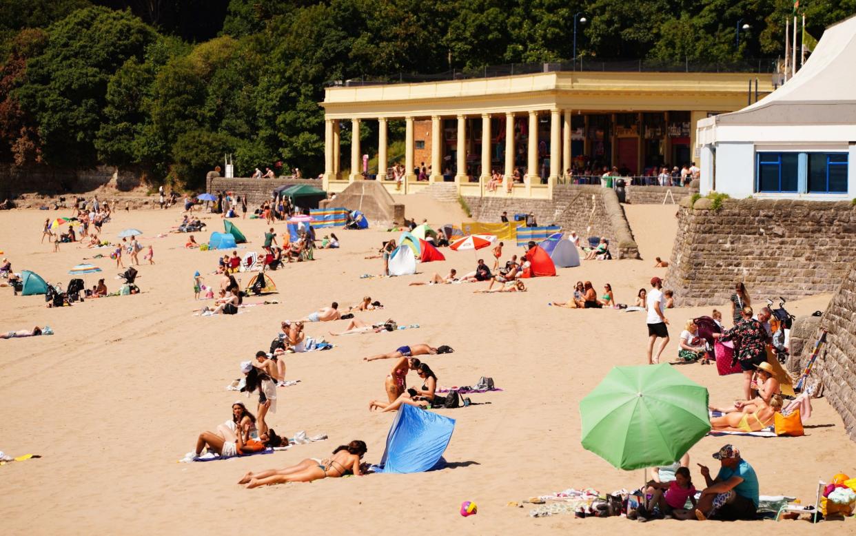 Sunbathers enjoy the hot temperatures on the beach at Barry Island, Wales - Ben Birchall/PA