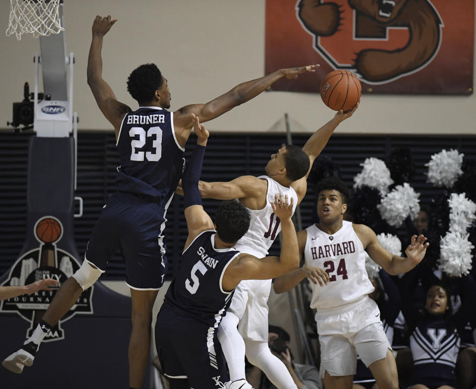 Harvard's Bryce Aiken (11) shoots as Yale's Jordan Bruner (23) and Yale's Azar Swain (5) defend during the first half of an NCAA college basketball game for the Ivy League championship at Yale University in New Haven, Conn., Sunday, March 17, 2019, in New Haven, Conn. (AP Photo/Jessica Hill)