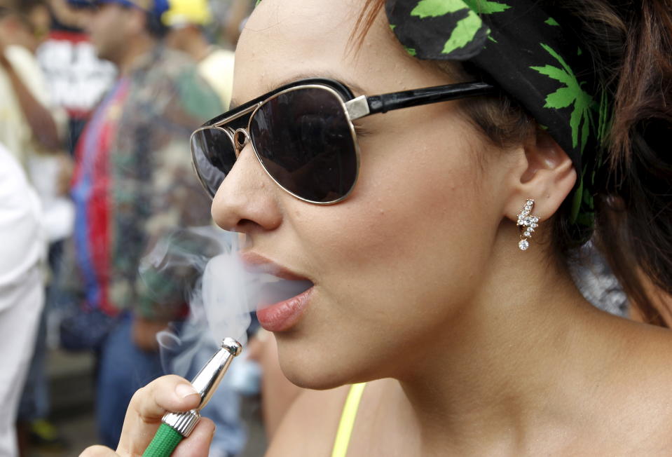 A woman smokes marijuana during a demonstration in support of the legalization of marijuana in Medellin, May 2, 2015. REUTERS/Fredy Builes