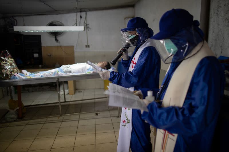 The Wider Image: Hazmat suits and holy water: two priests bring faith to Philippines lockdown