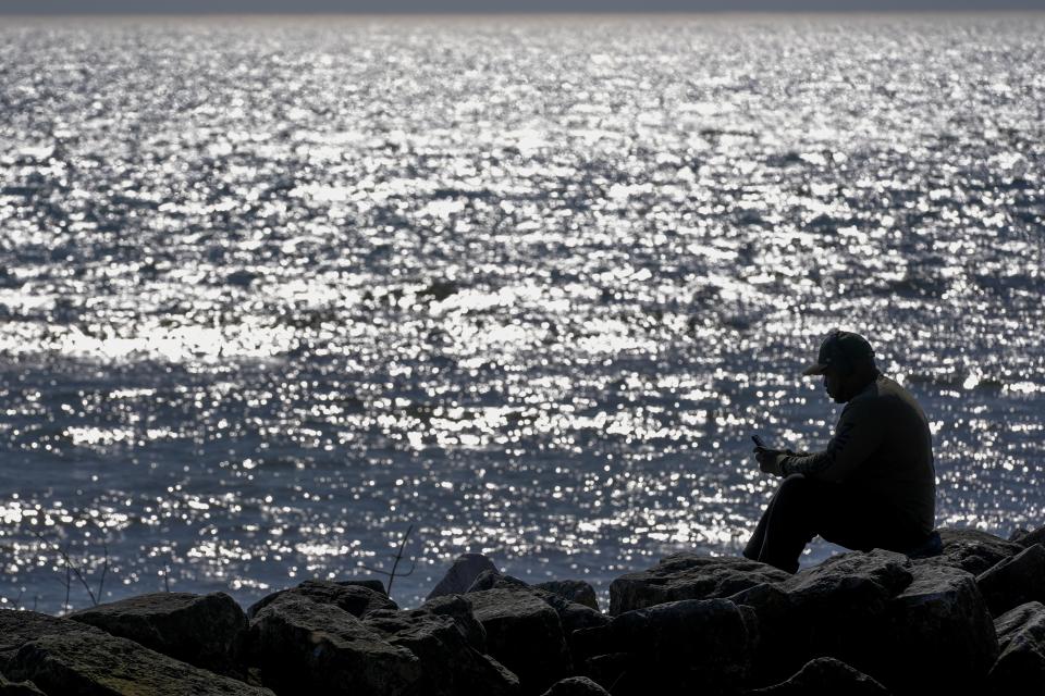 A man enjoy unseasonably warm weather along the shores of Lake Michigan Tuesday, Feb. 27, 2024, in Milwaukee. (AP Photo/Morry Gash)