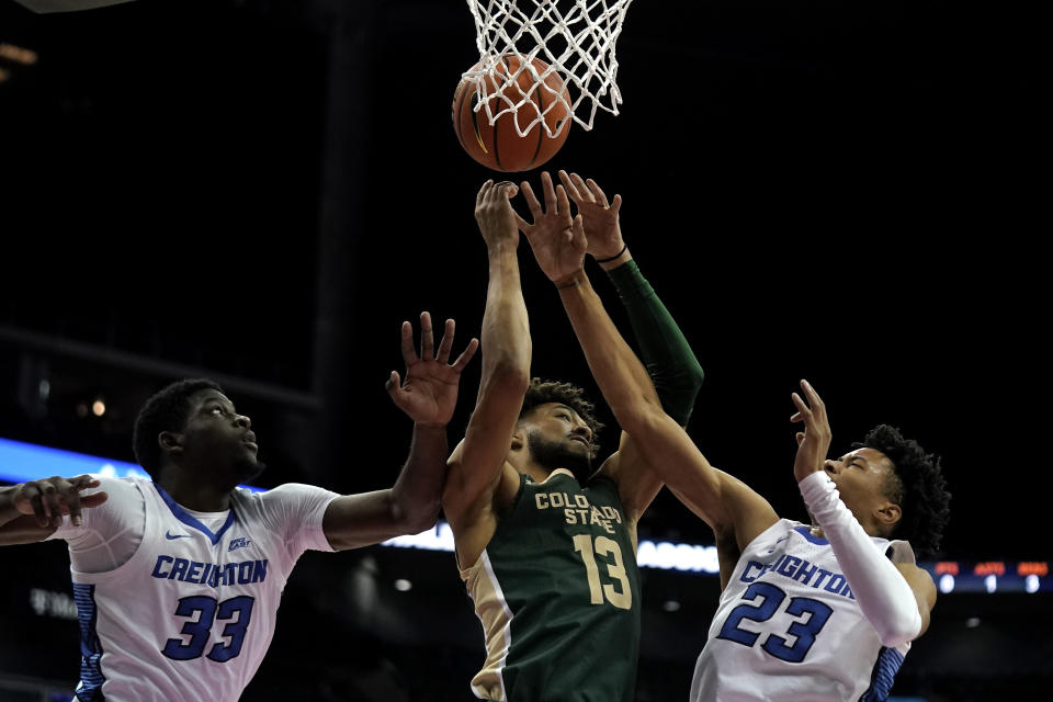 Colorado State guard Javonte Johnson (13) battles for a rebound with Creighton center Fredrick King (33) and guard Trey Alexander (23) during the second half of an NCAA college basketball game Thursday, Nov. 23, 2023, in Kansas City, Mo. Colorado State won 69-48. (AP Photo/Charlie Riedel)