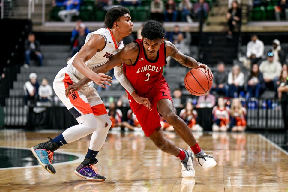 Warren Lincoln's Markus Blackwell, right, moves the ball as Flint Powers Catholic's Javontae Ross defends during the third quarter in the D2 boys basketball state semifinal on Friday, March 15, 2024, at the Breslin Center in East Lansing.