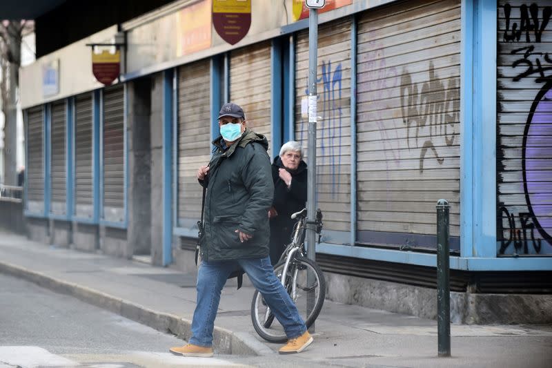 A man with a protective mask walks in Madama Cristina market in Turin