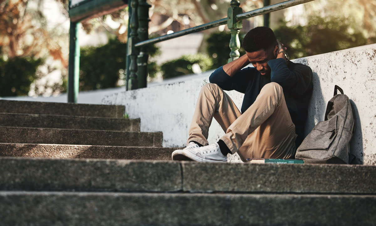 This is a photo of a stressed college students sitting outside.