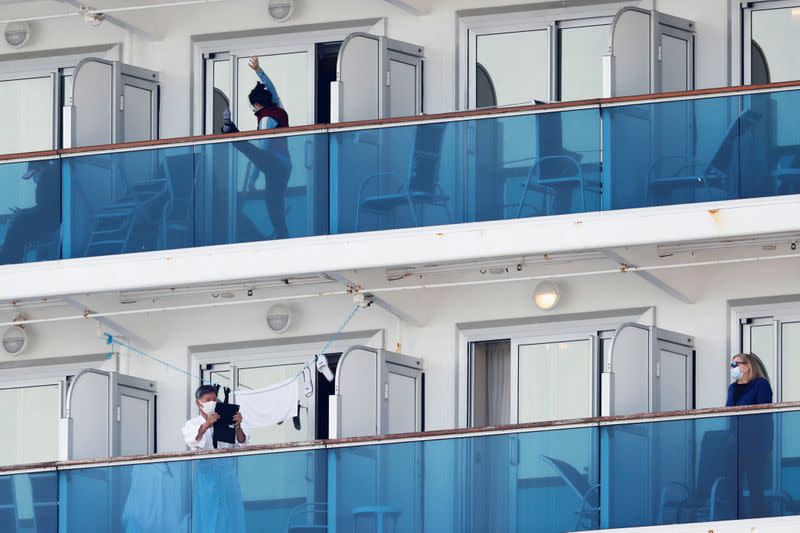 Passengers are seen on the balconies of their cabins of the cruise ship Diamond Princess at Daikoku Pier Cruise Terminal in Yokohama, south of Tokyo