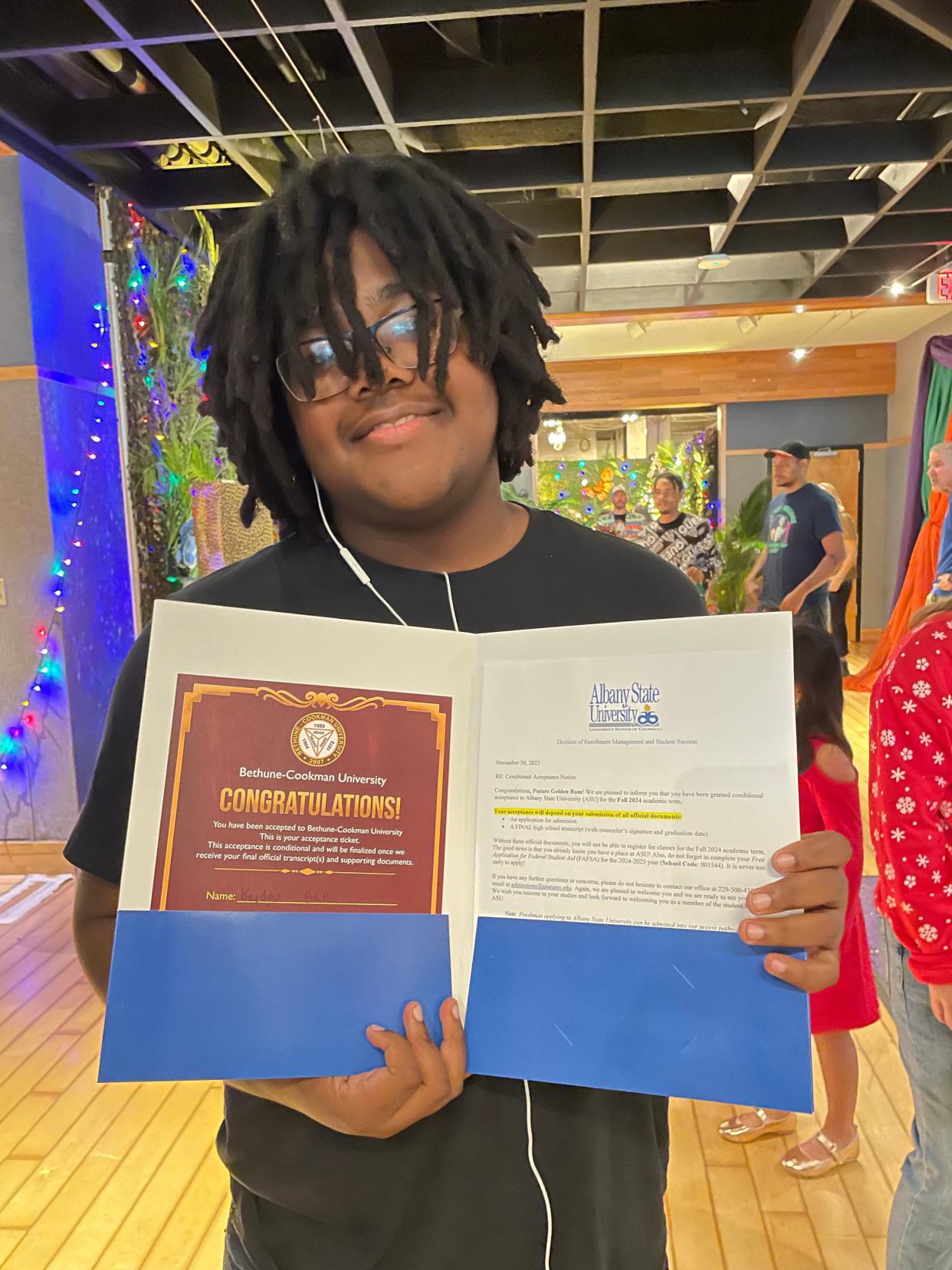 High school senior Keyden Hall shows off his two college acceptance letters during the Tom Coughlin Jay Fund's recent holiday party. Diagnosed at age 11 with acute lymphoblastic leukemia, the teen underwent more than two years of chemotherapy treatments and numerous other challenges.