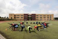 Kenyan athletes warm up before a training session in Nairobi