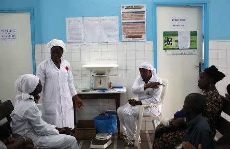 Nurses talk near a poster (C) displaying a government message against Ebola, at a maternity hospital in Abidjan August 14, 2014. REUTERS/Luc Gnago