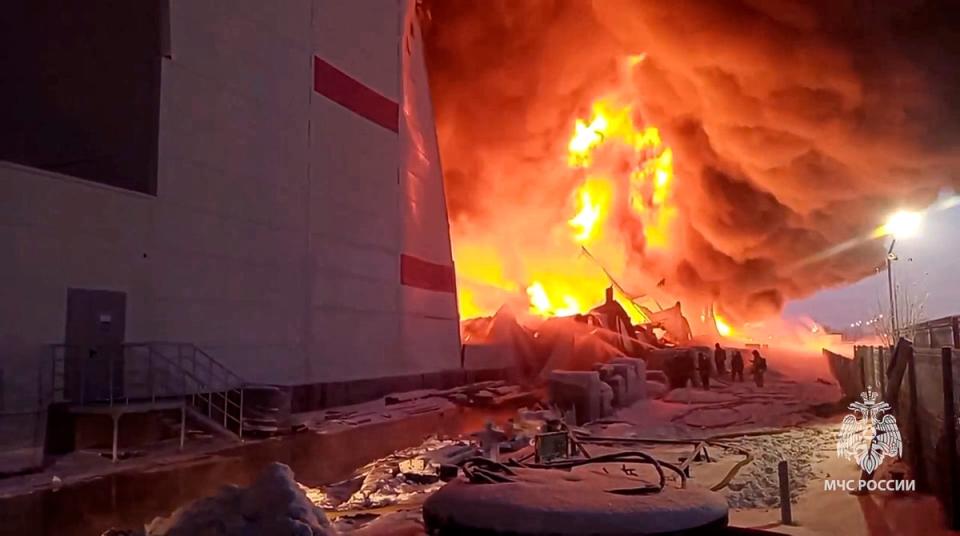 Russian Emergency Situations Ministry firefighters work at the side of the warehouse in St Petersburg, Russia (AP)