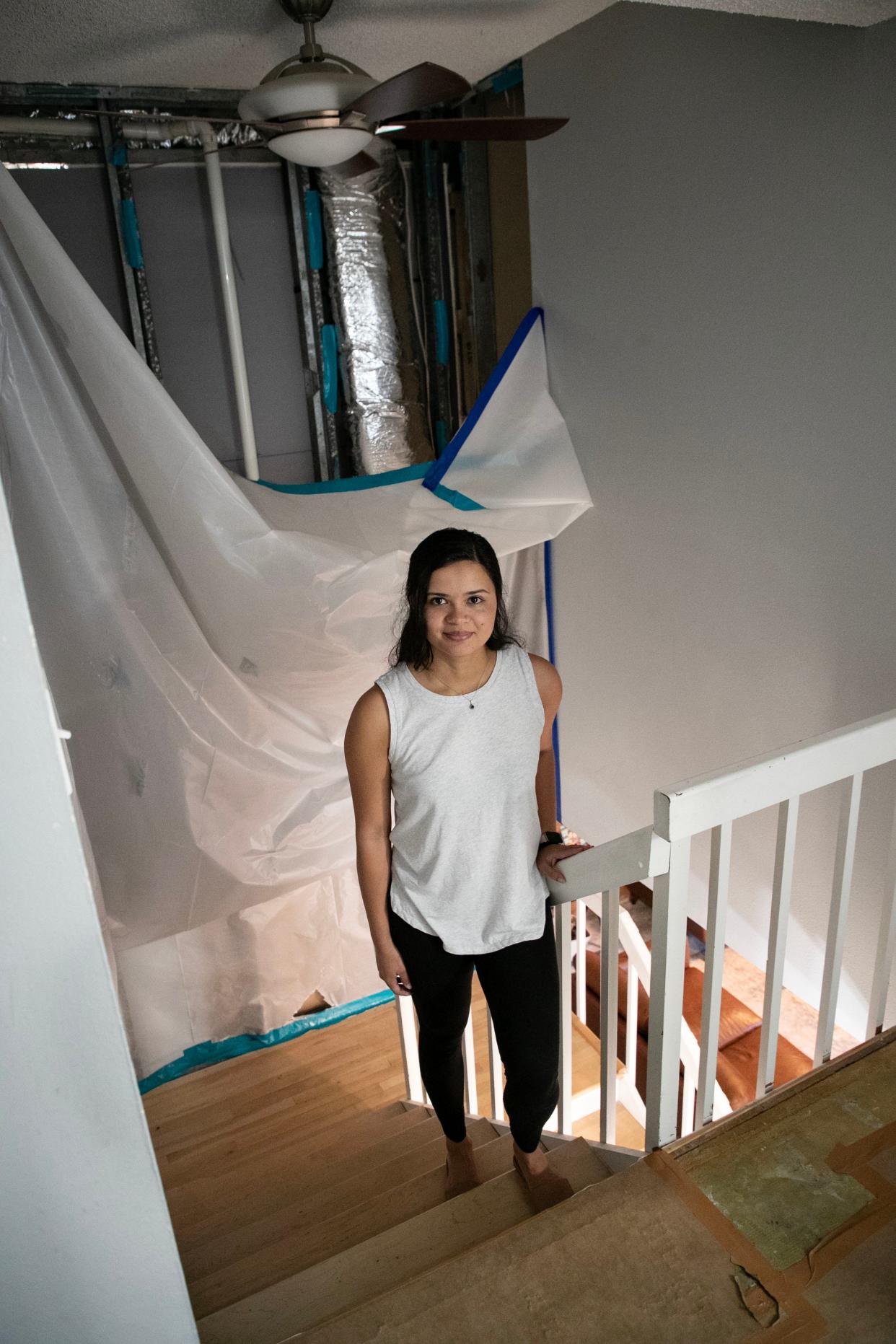 Sara Alvarez and her husband have been living with plastic and brown paper covering most of their walls since Hurricane Ian. Some of their drywall had to be removed after the roof was damaged, and they haven't been able to make repairs since the roof is still not fixed.