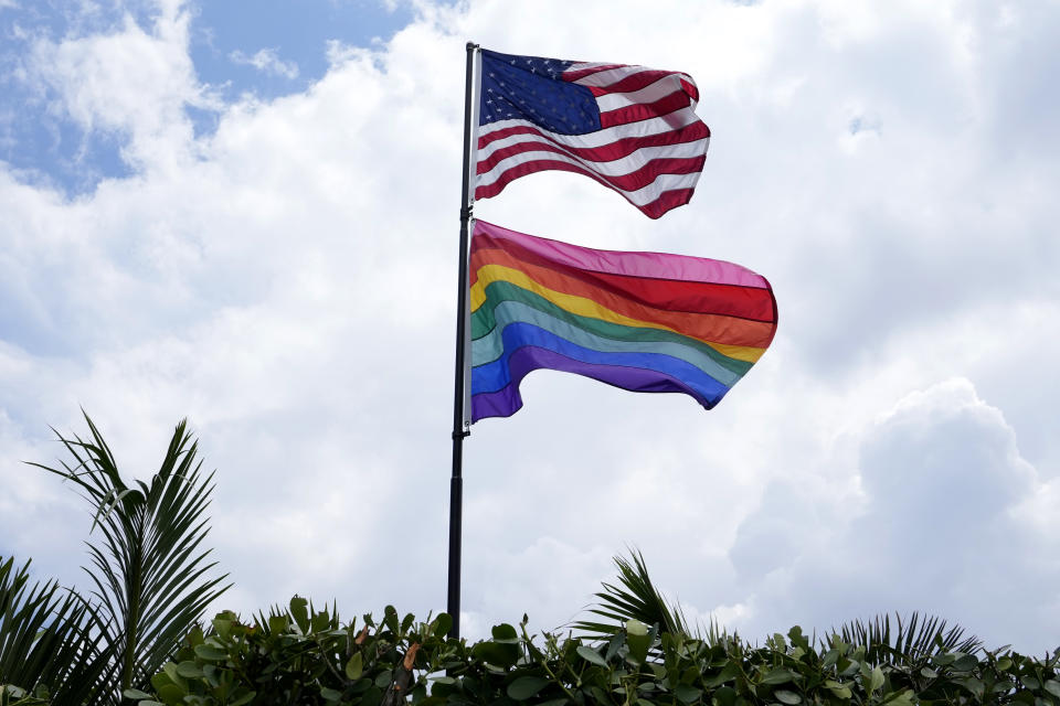 An American flag flies with a pride flag outside of a home in Wilton Manors, Fla., Thursday, June 29, 2023. (AP Photo/Lynne Sladky)