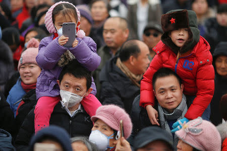 People, some wearing face mask against pollution, follow performers during a re-enactment of an ancient Qing Dynasty ceremony as the Lunar New Year of the Rooster is celebrated at the temple fair at Ditan Park (the Temple of Earth), in Beijing, China January 28, 2017. REUTERS/Damir Sagolj