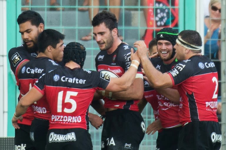 Toulon's Number 8 Charles Ollivon (C) is congratulated by teammates after scoring a try on September 25, 2016