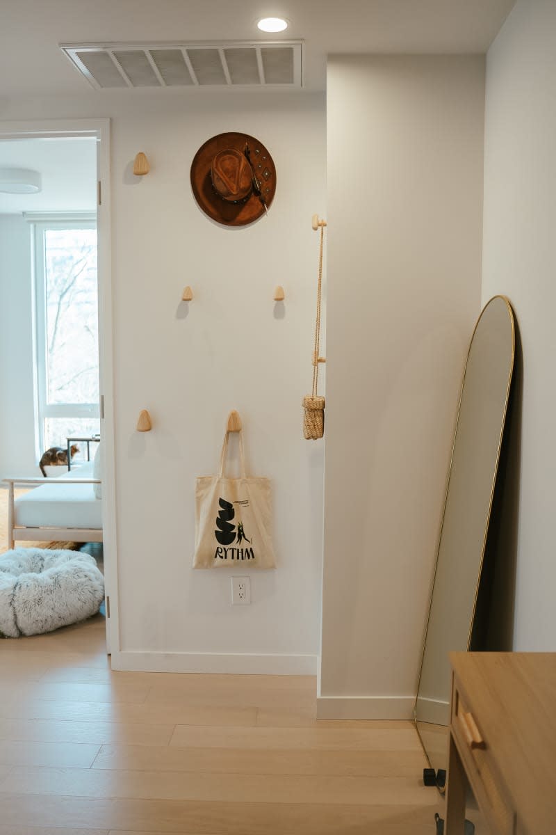 Tote bag on wooden hooks in bedroom.